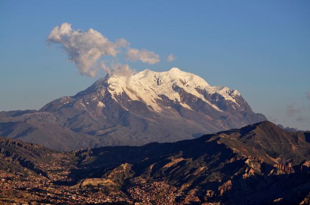 Snow-coated triple peak of Illimani mountain along the Cordillera Real range