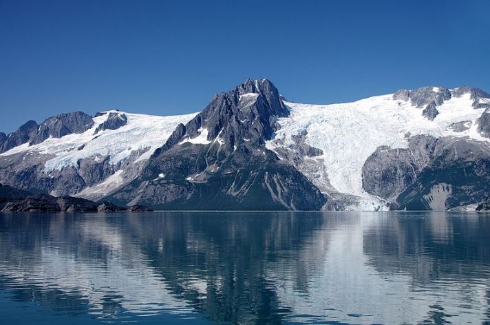The peaks of Kenai Fjords National Park reflected on the waters