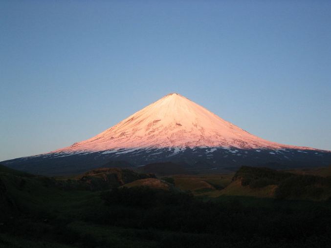 View of Klyuchevskaya volcano with the sun’s light reflection on almost half of its body