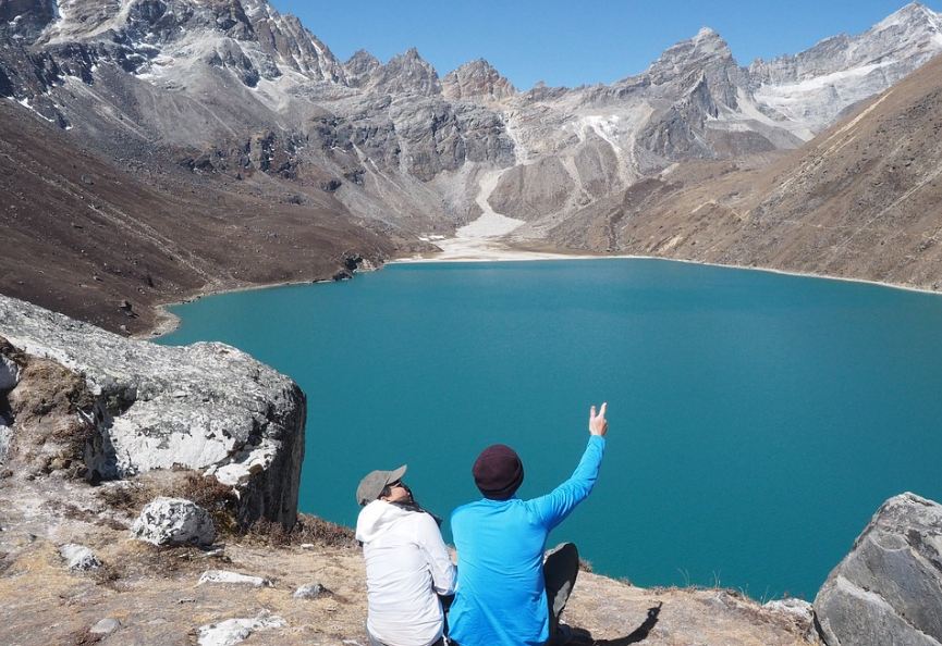 two tourists at Gokyolake in the middle of mountain ranges in Nepal