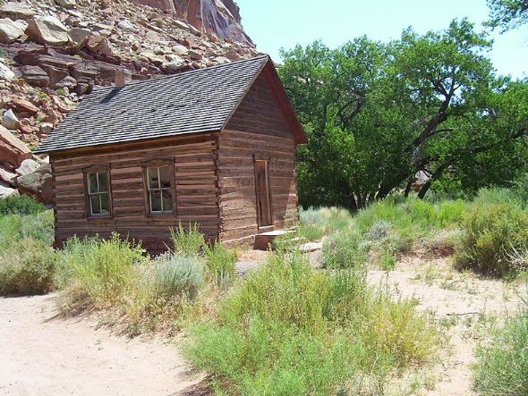 A wooden Fruita schoolhouse in the tiny community at the foot of a Capitol Reef canyon wall.