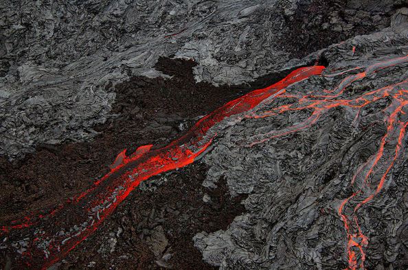 Pahoehoe lava flows over dried grey basaltic rocksnear the slopes of Kilauea