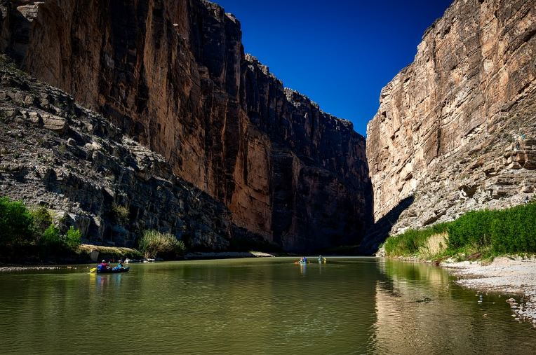 People kayaking at Rio Grande River between canyons