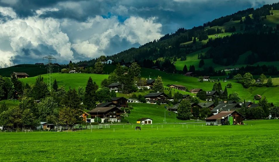 houses on a green valley and hilly side of Gstaad