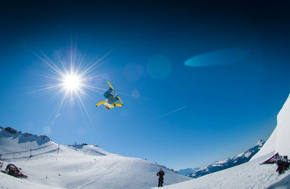 skiers doing exhibitions in the air under a sunny weather