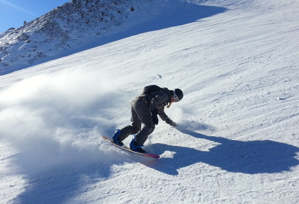 A man snowboarding on a thick a slope with thick snow