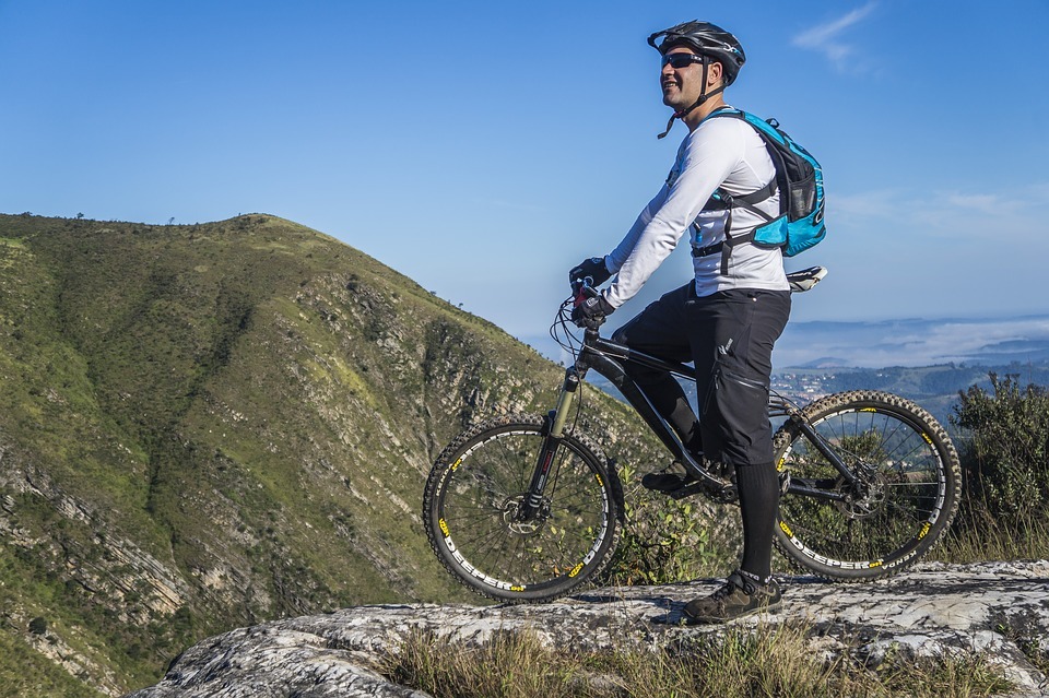 a cyclist on his bike against a mountainous background