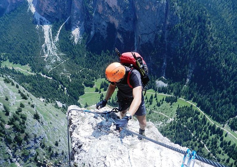 a man on top of the Ferrata Sandro Pertini in the Dolomites, Italy
