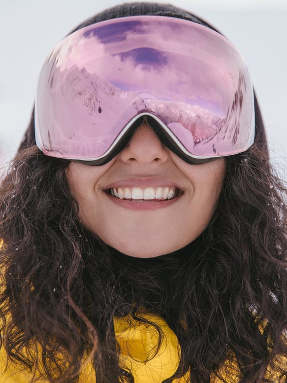 a woman wearing purple ski goggles